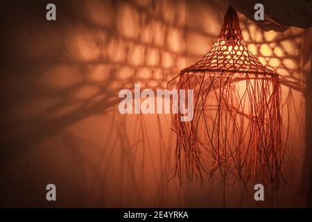 Lampada di bambù in stile boho moderno, tropicale, bohémien con ombre sulle pareti Foto Stock