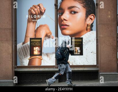 Edimburgo, Scozia, Regno Unito. 25 gennaio 2021. Il grande magazzino Jenners su Princes Street a Edimburgo annuncia che chiudersi definitivamente il 3 maggio con la perdita di 200 posti di lavoro. Frasers, il suo proprietario, dice che non è riuscito a concordare l'affitto con il proprietario dell'edificio Anders Polvsen. PIC; membro del pubblico passa davanti alla vetrina nel negozio chiuso di Jenners oggi. Iain Masterton/Alamy Live News Foto Stock