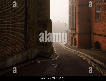 Foggy strada tra gli edifici di Harrow sulla collina in Inghilterra Foto Stock