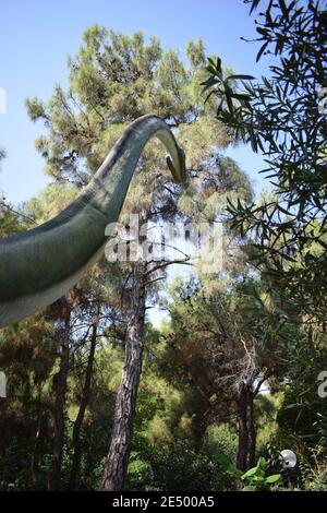 Statua di dinosauro nel parco forestale in natura per sfondo. Modello realistico di Dinosaur è in piedi nella giungla, con il suo collo lungo a facile mangiare foglia Foto Stock
