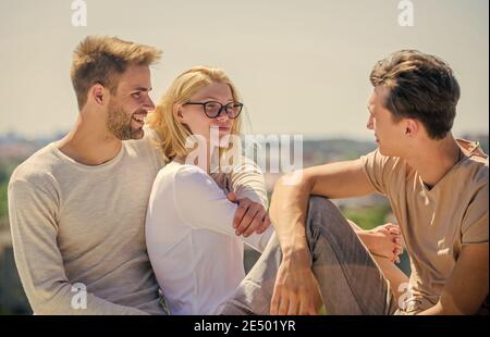 Storia romantica. Amici allegri. Relazioni di amicizia. Famiglia e amore. Vacanza estiva. Tempo di relax. Gruppo di persone all'aperto. Week-end in famiglia. Ragazza felice e due uomini. Foto Stock