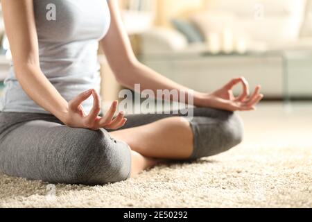 Primo piano di una donna che fa esercizio di yoga su mani un tappeto a casa Foto Stock