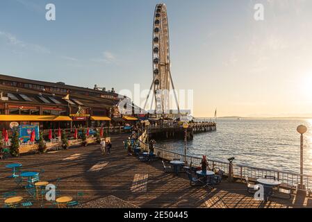 La Seattle Great Wheel sorge a 175 metri sul Molo 57, affacciato sullo skyline di Seattle e sulla Elliott Bay mentre il sole tramonta ad ovest Foto Stock