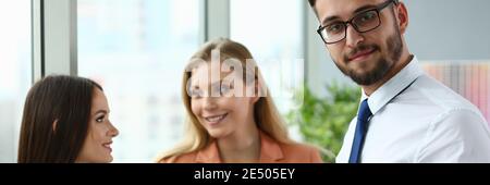 Tre giovani dipendenti che chiacchierano in ufficio Foto Stock