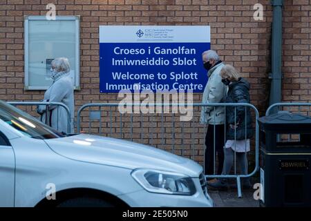 Cardiff, Galles, Regno Unito. 25 Gennaio 2020. Le persone si accodano per il vaccino del coronavirus al di fuori di un centro di immunizzazione nella zona di Splott di Cardiff. Il ministro della salute del Galles, Vaughan Gething, oggi ha affermato che non è chiaro se sia stato raggiunto un impegno a vaccinare il 70% degli over-80 e di coloro che si trovano nelle case di cura. Credit: Mark Hawkins/Alamy Live News Foto Stock