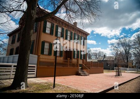 Springfield, Illinois - 15 marzo 2019; vista retroilluminata dell'ingresso anteriore della casa Abraham Lincoln in legno marrone e verde e del parco nazionale dell'Illinois Foto Stock