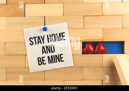 Soggiorno a casa e felice giorno di San Valentino idea immagine con iscrizione di testo, nuovo 2021 anni, seduta a casa, notebook con perni di carta con promemoria e due h rosso Foto Stock