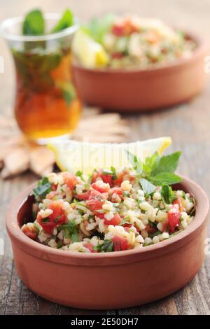 Tabulé con bulgur, pomodori, prezzemolo, menta, e limone Foto Stock