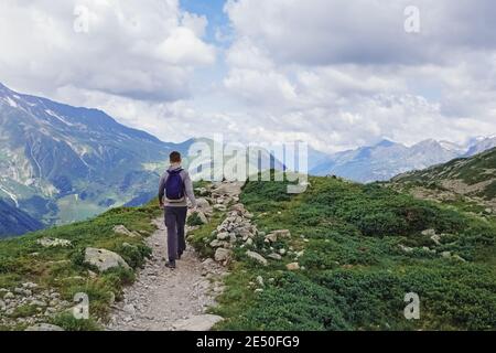 Uomo con uno zaino escursioni in montagna estate. Foto Stock