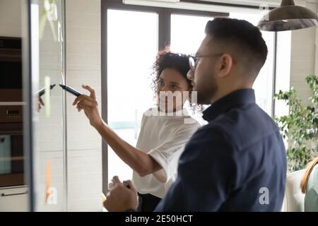 Primo piano di sviluppo di diversi colleghi, scrivendo su una parete di vetro Foto Stock