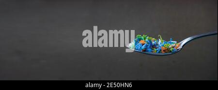 Primo piano di microplastica in un cucchiaio. Concetto creativo di inquinamento idrico e riscaldamento globale. Idea del cambiamento climatico. Messa a fuoco principale sul cucchiaio. Foto Stock