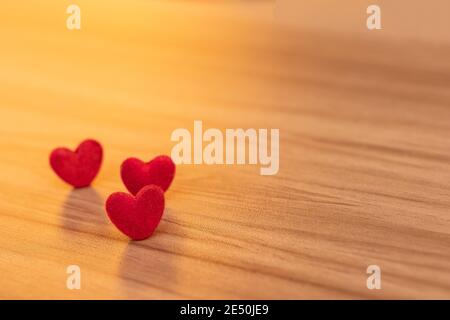 Primo piano i cuori rossi sono posti sul tavolo di legno. San Valentino sfondo e texture. Foto Stock