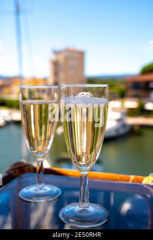 Festa estiva con spumante champagne e barca a vela paradiso di Port Grimaud sullo sfondo, Var, Provenza, Francia Foto Stock