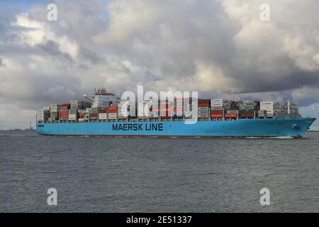 una grande nave da carico naviga attraverso il fiume schelda vicino inverno con grandi nuvole nel cielo Foto Stock