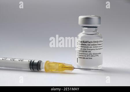 Flaconcino e siringa di vaccino originale Pfizer BioNTech COVID-19 accanto ad esso. Foto di vaccino reale. Messa a fuoco selettiva. Stafford, Regno Unito - Gennaio 23 2021. Foto Stock