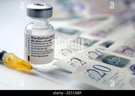 Flaconcino di vaccino originale Pfizer BioNTech COVID-19 posto accanto alle note della libbra britannica. Foto di vaccino reale. Messa a fuoco selettiva. Stafford, Regno Unito - Janu Foto Stock