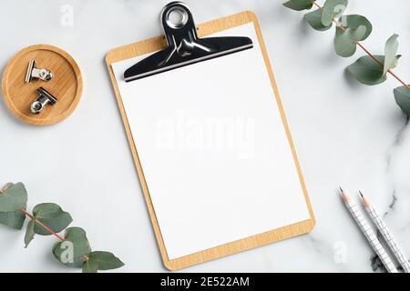 Area di lavoro home Office mockup con appunti, foglie di eucalipto, forniture per ufficio su tavolo da lavoro in marmo. Disposizione piatta, vista dall'alto, spazio per la copia. Foto Stock