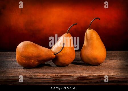 Tre grandi pere bosc gialle su un tavolo di legno di fienile e grunge sfondo Foto Stock