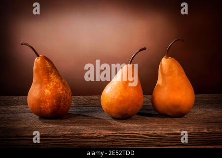 Tre grandi pere bosc gialle su un tavolo di legno di fienile e grunge sfondo Foto Stock