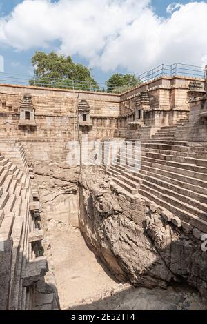 Lakkundi, Karnataka, India - 6 novembre 2013: Tanica a gradini Musakeena Bhavi. Sole in buca asciutta e profonda dove le scale non raggiungono. Fogliame verde sul terreno l Foto Stock