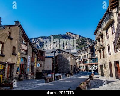 Edifici medievali si trovano contro le montagne dei Pirenei, nella strada della città parrocchiale di Ordino, Andorra Foto Stock