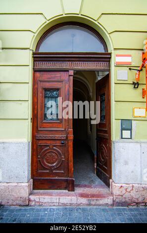 Elegante porta di legno marrone in un edificio con pareti verdi, stile barocco. Patrimonio storico nella città europea di Budapest, Ungheria. Foto Stock