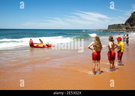 Volontari salvataggio surf lifesavers lanciare gonfiabile rosso zodiac salvataggio surf Barca a Bilgola Beach a Sydney, NSW, Australia Foto Stock