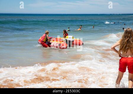 Volontari salvataggio surf lifesavers lanciare gonfiabile rosso zodiac salvataggio surf Barca a Bilgola Beach a Sydney, NSW, Australia Foto Stock