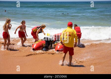 Volontari salvataggio surf lifesavers lanciare gonfiabile rosso zodiac salvataggio surf Barca a Bilgola Beach a Sydney, NSW, Australia Foto Stock