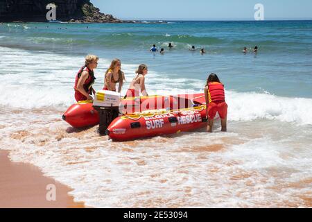 Volontari salvataggio surf lifesavers lanciare gonfiabile rosso zodiac salvataggio surf Barca a Bilgola Beach a Sydney, NSW, Australia Foto Stock