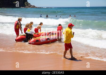 Volontari salvataggio surf lifesavers lanciare gonfiabile rosso zodiac salvataggio surf Barca a Bilgola Beach a Sydney, NSW, Australia Foto Stock