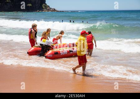 I salvagente volontari lanciano una barca di salvataggio da surf gonfiabile con zodiaco rosso a Bilgola Beach a Sydney, NSW, Australia nel 2021 Foto Stock