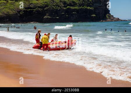 Volontari salvataggio surf lifesavers lanciare gonfiabile rosso zodiac salvataggio surf Barca a Bilgola Beach a Sydney, NSW, Australia Foto Stock