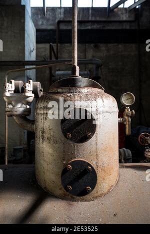 Vista simmetrica del locale caldaia in un vecchio e. Abbandonata fabbrica tessile italiana Foto Stock