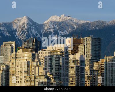 Vancouver, British Columbia, Canada. 7 gennaio 2021. West Crown Mountain (a sinistra) innevata e Crown Mountain (a destra) formano uno sfondo panoramico per le alte torri condominiali nel centro di Vancouver. Credit: Bayne Stanley/ZUMA Wire/Alamy Live News Foto Stock