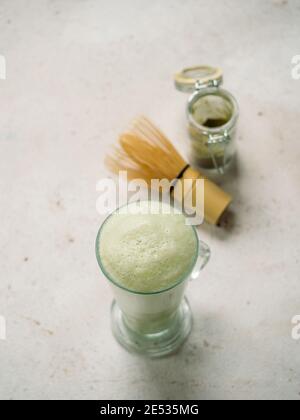 Texture di schiuma verde estrema da vicino come sfondo. Perfetta schiuma di latte di tè verde matcha con bolle macro sparare. Spazio di copia per il testo. Verticale. Foto Stock