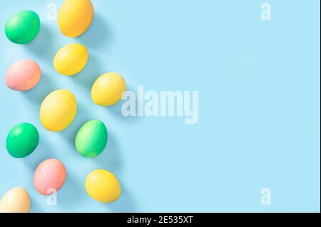 Belle uova di pasqua colorate isolate su sfondo blu. Buona Pasqua. Congratulazioni pasqua background. Uova pasquali pastello su fondo blu Foto Stock