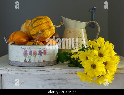Ancora vita con zucche e un bouquet di crisantemi gialli. Vintage. Foto Stock