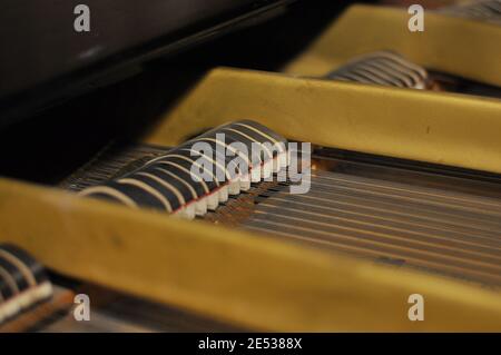 Meccanismo piano. All'interno del pianoforte a coda. Vista ravvicinata dei martelli, delle corde all'interno del pianoforte. Foto Stock