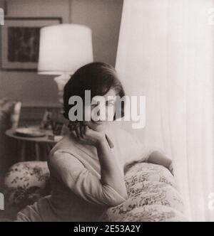 Prima fotografia ufficiale della Casa Bianca di Jacqueline Kennedy, ritratto di mezza lunghezza, seduto sul divano, rivolto verso la parte anteriore. STATI UNITI. 1961 Jacqueline Lee Kennedy Ona Foto Stock