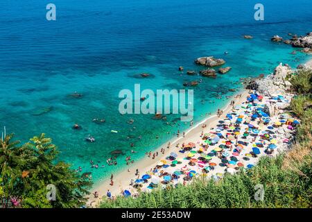 Spiaggia di Michelino a Parghelia nei pressi di Tropea in estate, Calabria, Italia. Spiaggia di sabbia piena di turisti e ombrelloni colorati Foto Stock