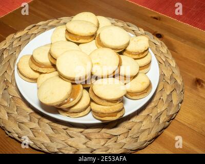 Gli alfajores tradizionali in Argentina, Perù e Uruguay consistono di due biscotti dolci rotondi fatti di farina di grano o amido di mais Uniti insieme con il dul Foto Stock