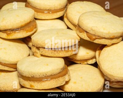 Gli alfajores tradizionali in Argentina, Perù e Uruguay consistono di due biscotti dolci rotondi fatti di farina di grano o amido di mais Uniti insieme con il dul Foto Stock