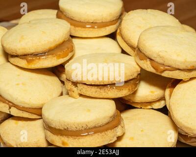 Gli alfajores tradizionali in Argentina, Perù e Uruguay consistono di due biscotti dolci rotondi fatti di farina di grano o amido di mais Uniti insieme con il dul Foto Stock