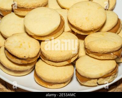 Gli alfajores tradizionali in Argentina, Perù e Uruguay consistono di due biscotti dolci rotondi fatti di farina di grano o amido di mais Uniti insieme con il dul Foto Stock