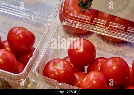 Pomodori freschi da supermercato confezionati in scatole di plastica trasparente con coperchi. Foto Stock