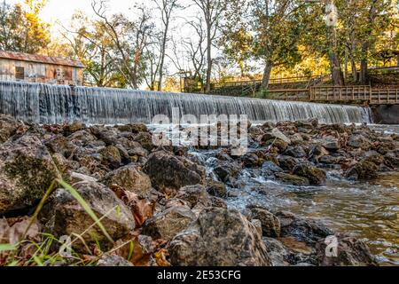 Childersburg, Alabama/USA-10 novembre 2018: Punto di vista basso della fuoriuscita sul Talladega Creek con il Kymulga Covered Bridge sullo sfondo. Foto Stock