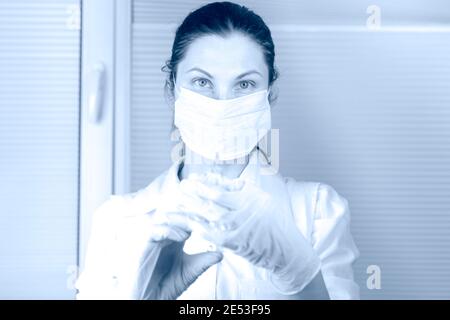 Medico operatore sanitario in maschera medica e guanti in clinica con siringa con vaccino.COVID-19 Coronavirus vaccino. Medico scienziato. Ricerca femminile Foto Stock