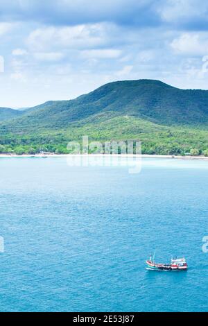 Vista aerea, una tradizionale barca da pesca torna a casa vicino a Koh Samae San in una giornata piovosa, nuvoloso sopra l'isola tropicale. Chon Buri, Thailandia. Foto Stock