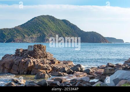 Con il monte Yacaaba sullo sfondo, i resti di una guerra mondiale due armi di collocazione prendere la luce del mattino all'ingresso di Port Stephens Foto Stock